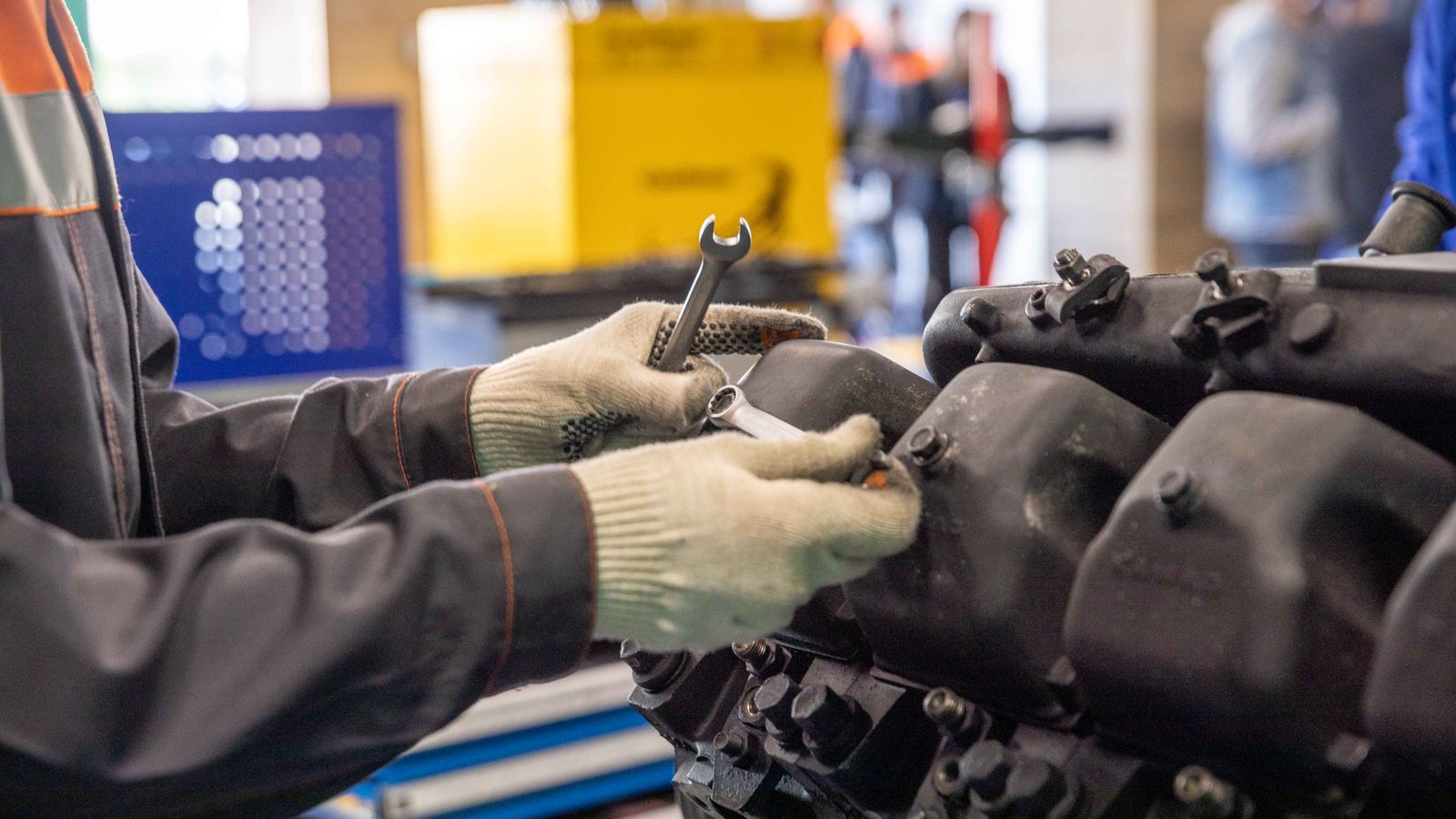 Mechanic inspecting an engine in a workshop, representative stock photography